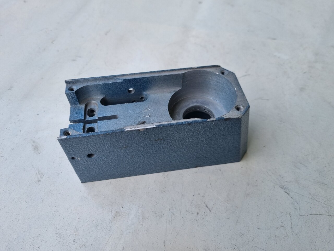 Na zdjęciu znajduje się wykonany z aluminium odlew obudowy urządzenia. Jest to sześcienna konstrukcja ze skomplikowaną siatką otworów wewnątrz. Przedstawiony odlew został pomalowany proszkowo na niebieski kolor zgodnie z życzeniem klienta.