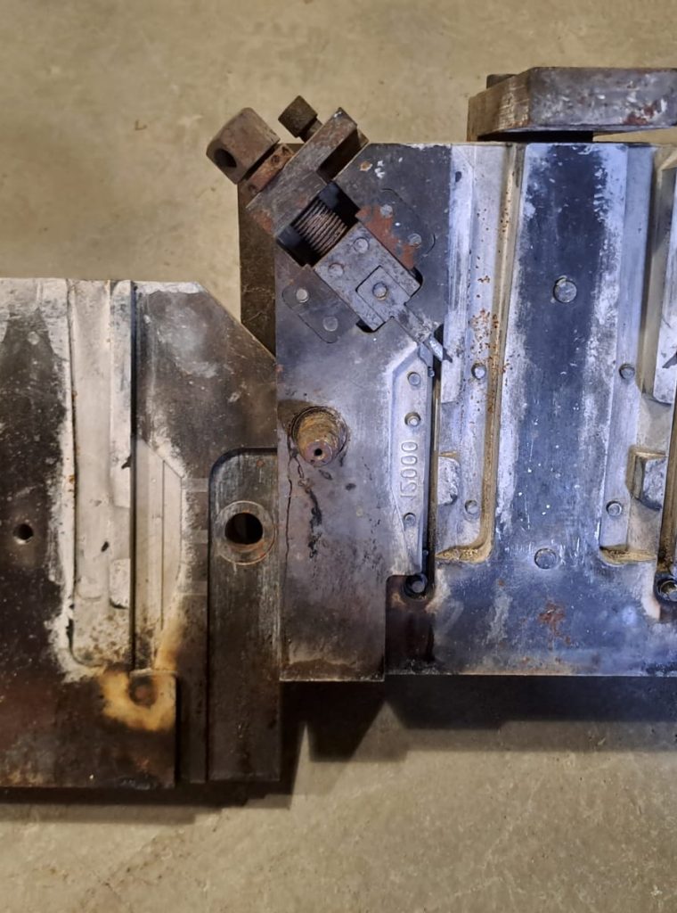 IMG-20240313-WA0007 Jest to kokila stalowa z której za jednym razem wychodzi jeden komplet zawiasów aluminiowych wykonywanych na zlecenie niemieckiej firmy zajmującej się produkcją okien i drzwi. Pokryta jest warstwą specjalnych pokryć które mają za zadanie zapewniać odpowiednie zasilanie odlewu w płynny metal a w niektórych sprawić iż zakrzepnie szybko dzięki czemu odlew będzie miał pożądany wygląd. Ponadto wydać iż u góry po obu stronach znajdują się wysuwane rdzenie dzięki czemu jesteśmy w stanie wykonać pożądany otwór bez potrzeby wiercenia w wykonanym odlewie.