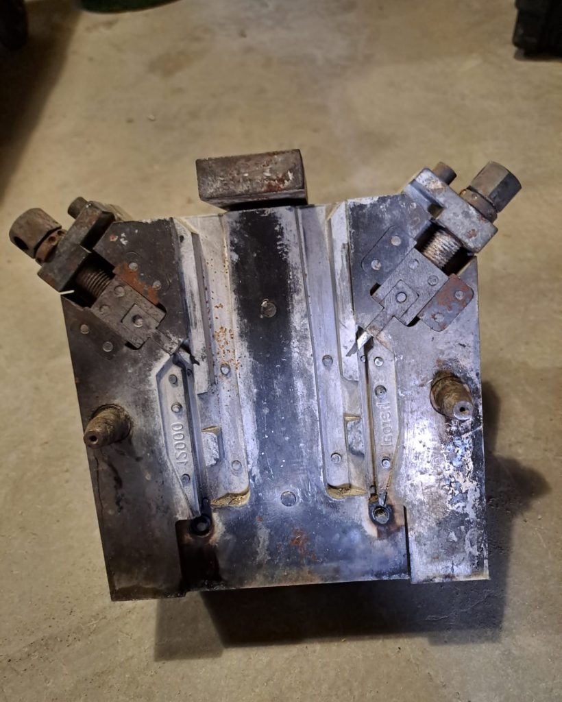 IMG-20240313-WA0009 Jest to jedna część kokili stalowej z której za jednym razem wychodzi jeden komplet zawiasów aluminiowych wykonywanych na zlecenie niemieckiej firmy zajmującej się produkcją okien i drzwi. Pokryta jest warstwą specjalnych pokryć które mają za zadanie zapewniać odpowiednie zasilanie odlewu w płynny metal a w niektórych sprawić iż zakrzepnie szybko dzięki czemu odlew będzie miał pożądany wygląd. Ponadto wydać iż u góry po obu stronach znajdują się wysuwane rdzenie dzięki czemu jesteśmy w stanie wykonać pożądany otwór bez potrzeby wiercenia w wykonanym odlewie.